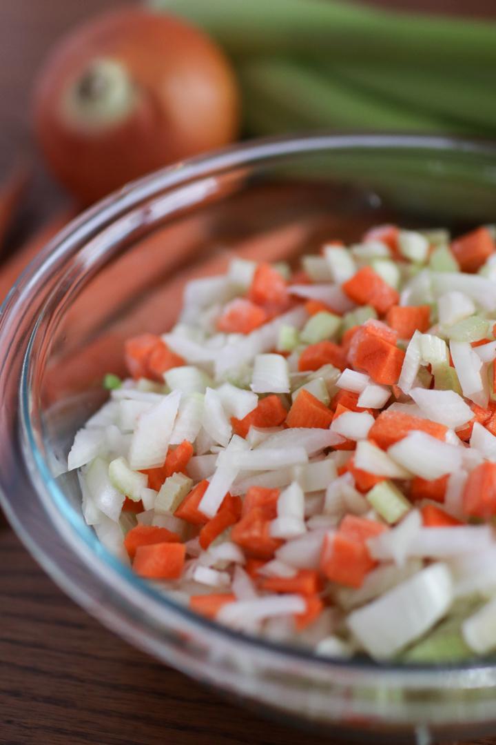 A bowl of raspberries with a lime wedge next to it