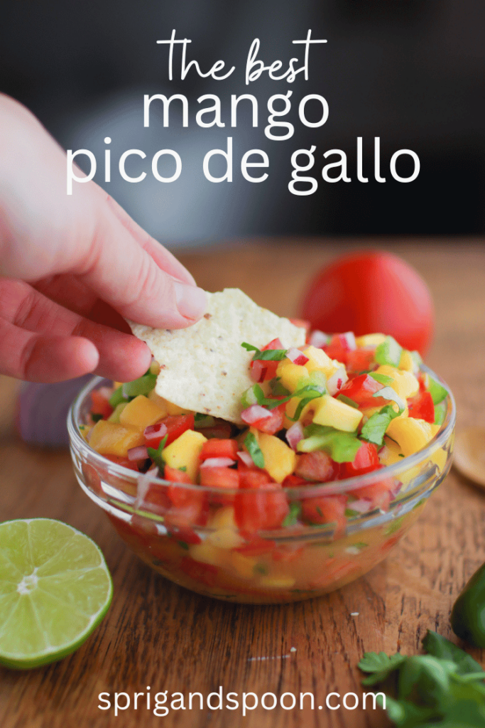 the best mango pico de gallo being scooped onto a chip