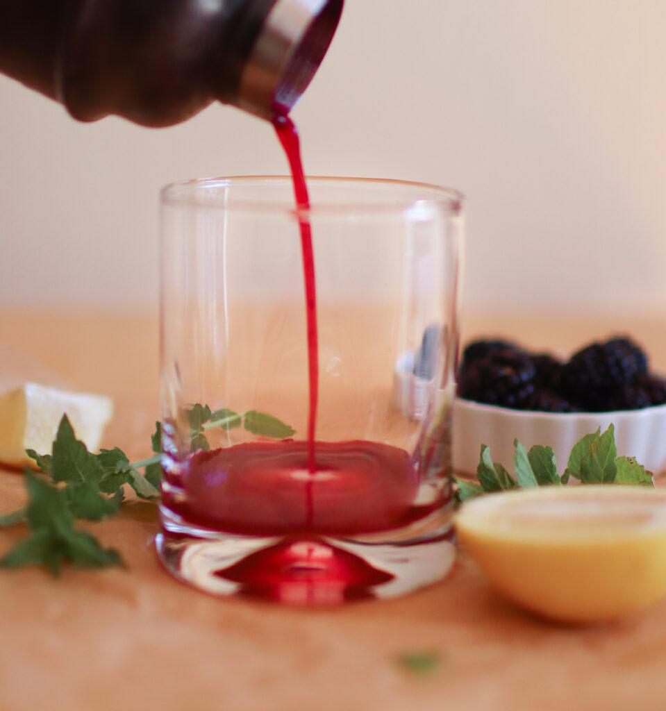 pouring cocktail into a glass