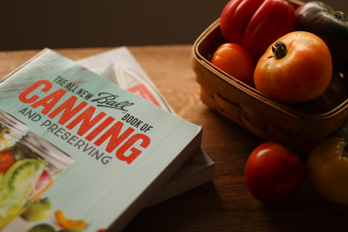 a stack of books and a basket of tomatoes