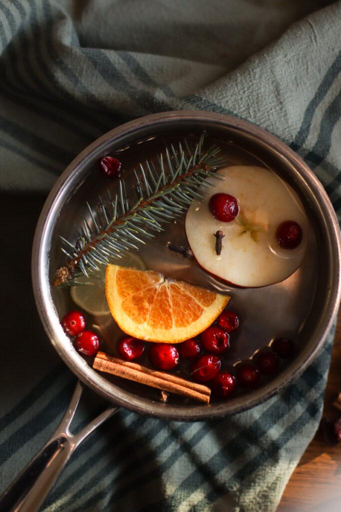 a fresh simmer pot with oranges, cranberries, apples, and pine