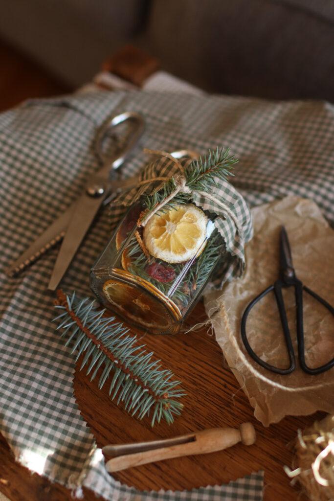a simmer pot kit on a table with scissors, fabric, and a vintage clothespin