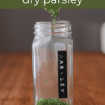 how to dry parsley with dried parsley being poured into a jar