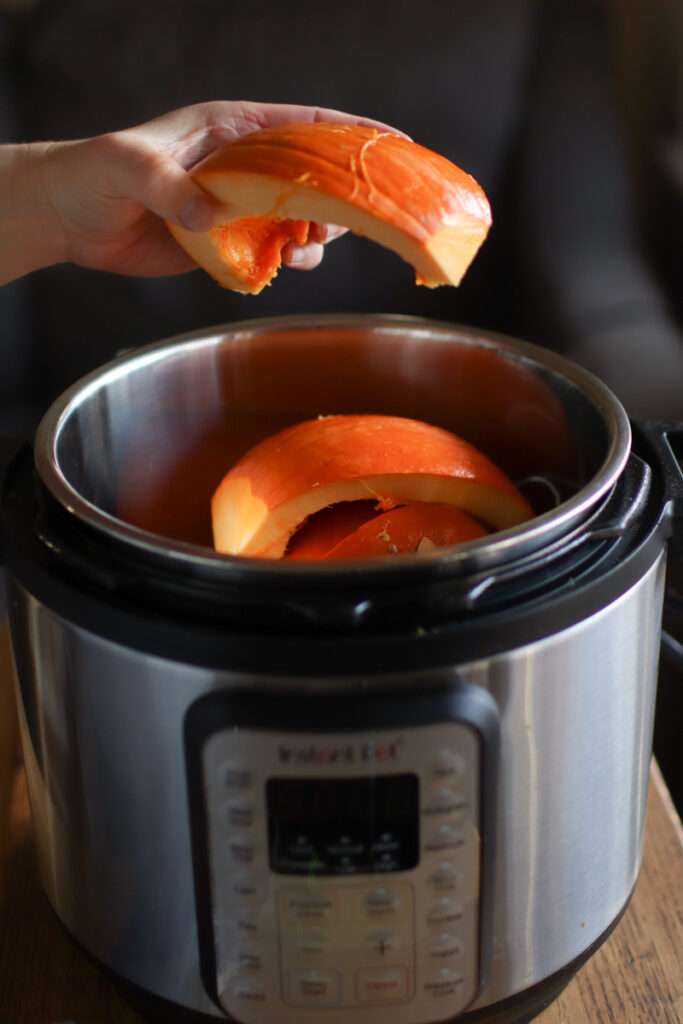 A pumpkin being placed in an instant pot