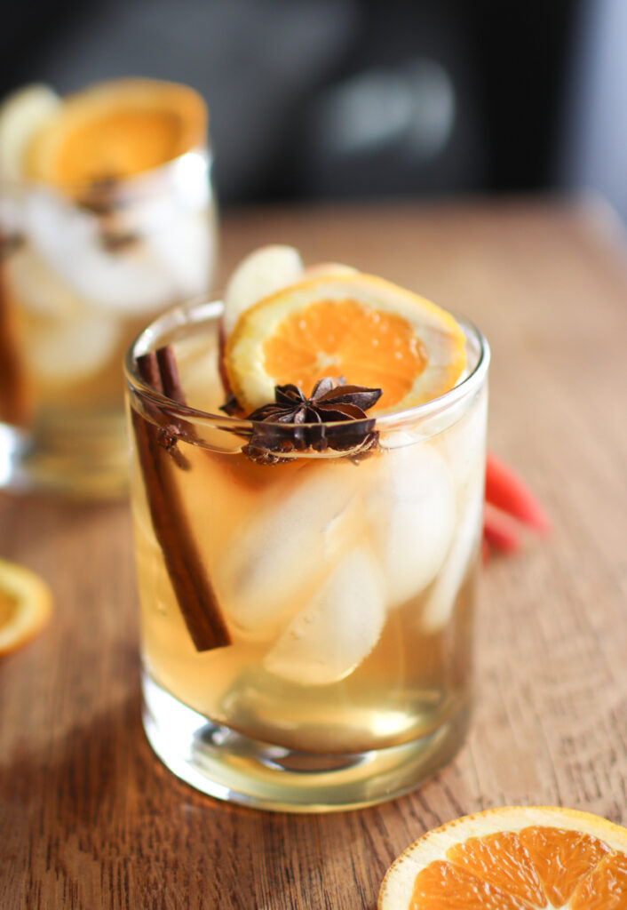 a glass of spiced rum punch with sliced oranges