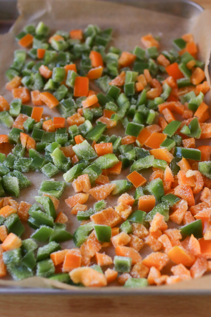 A baking sheet filled with frozen bell peppers.