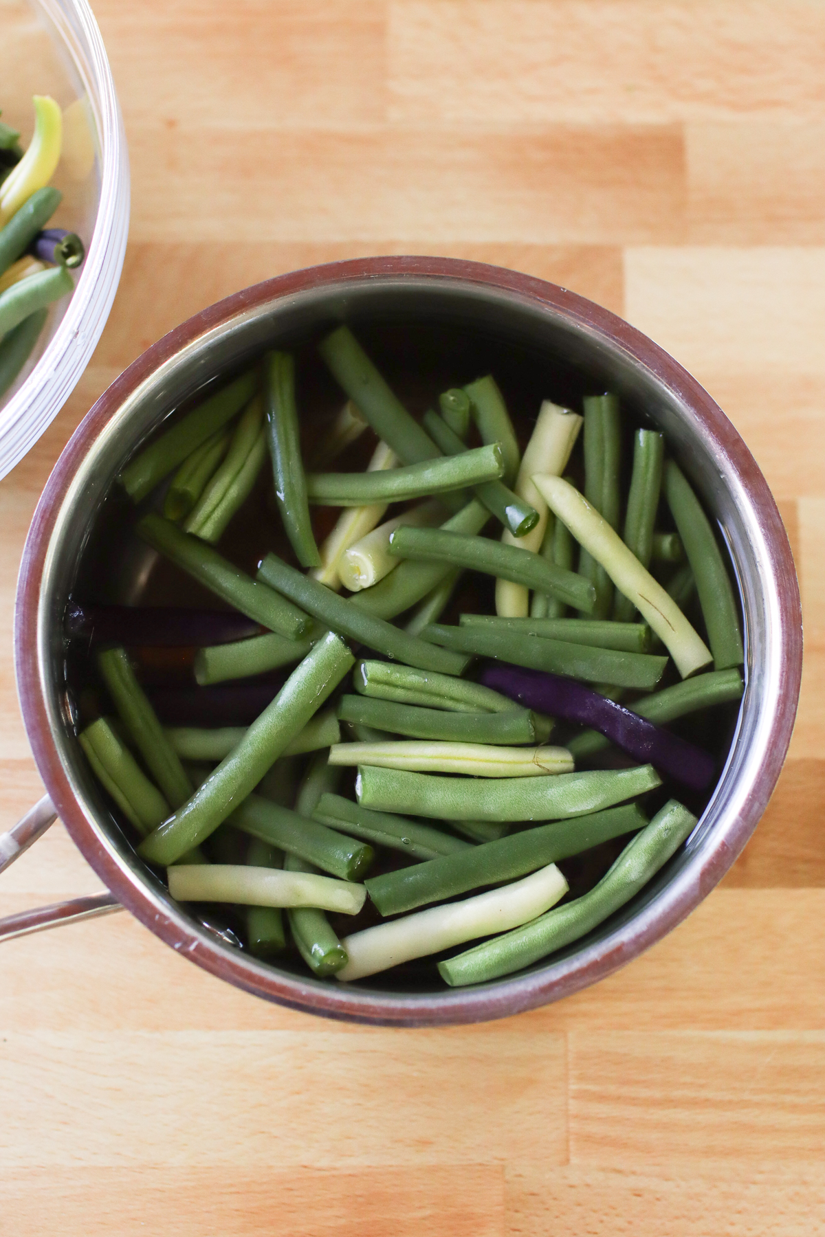 Trimmed green beans in a pot of water.