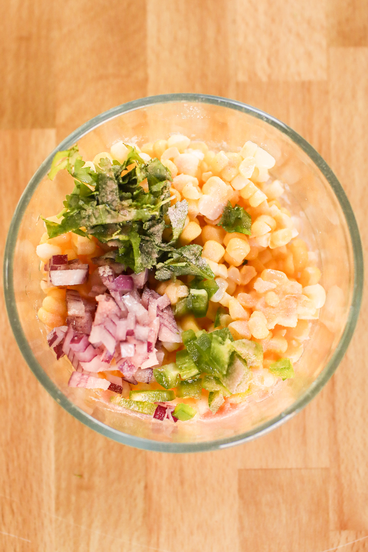 Corn salsa ingredients in a glass bowl. 
