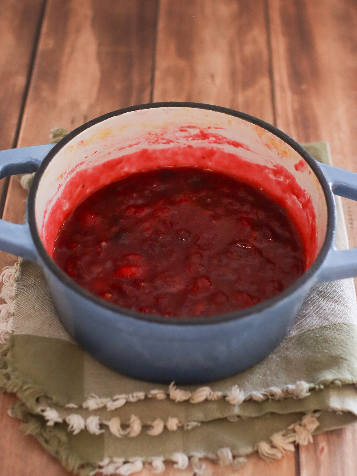 Cranberry sauce finished cooking in a small blue pot.