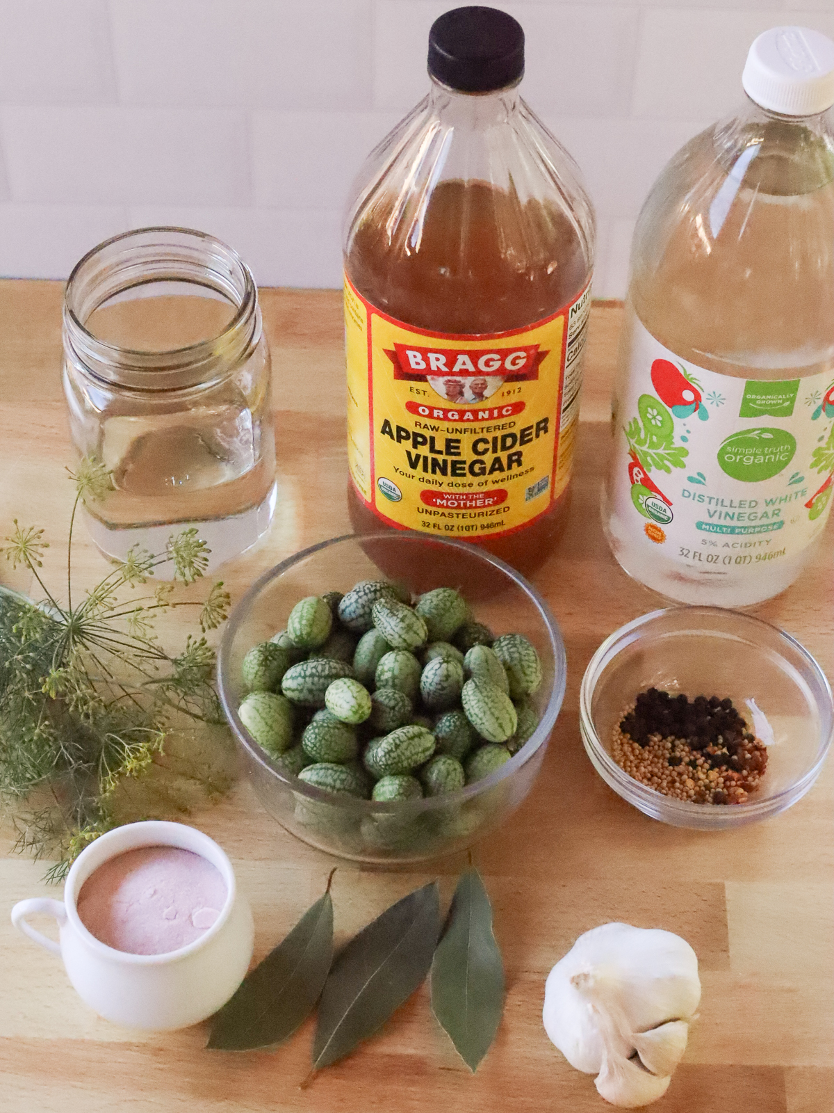 Cucamelon pickle ingredients assembled on a butcher block counter.
